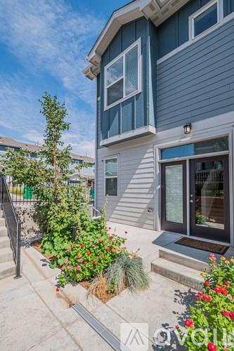 A house with a blue exterior and a garden in front.