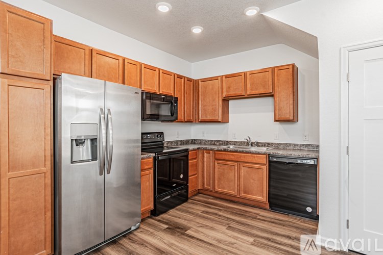 A kitchen with wooden cabinets and a stainless steel refrigerator.