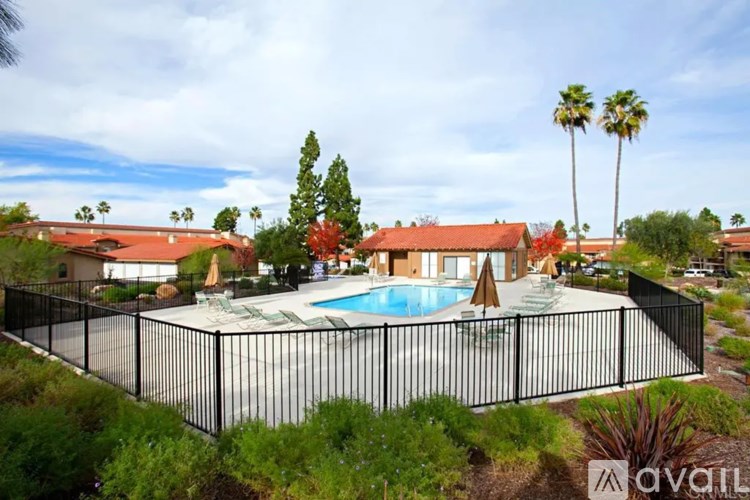 A house with a pool surrounded by a black fence.