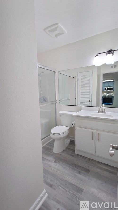 A bathroom with a toilet, sink, and shower.