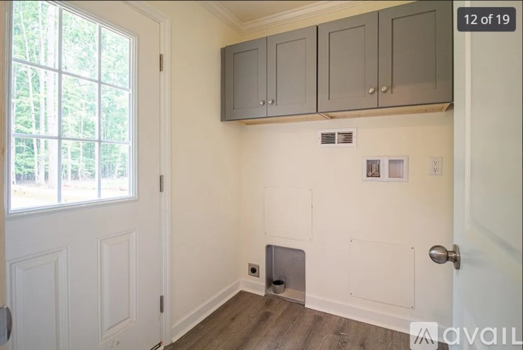 A room with a door, a window, and a wall-mounted cabinet.
