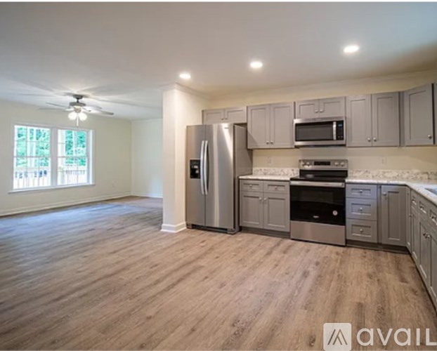 A kitchen with a refrigerator, oven, microwave, and cabinets.