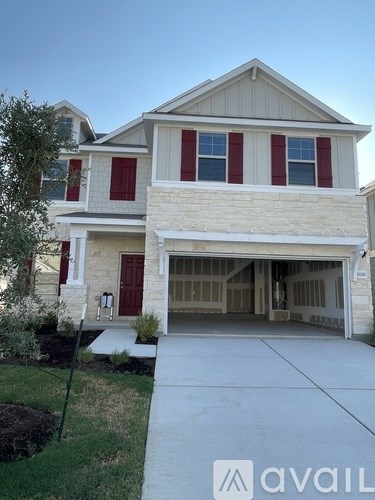 A two-story house with a garage and a driveway.