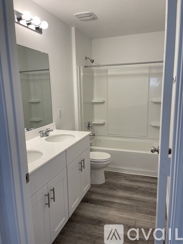 A bathroom with a white sink, toilet, and bathtub.