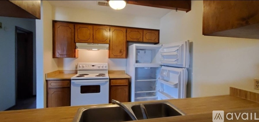 A kitchen with a white stove and a white refrigerator.