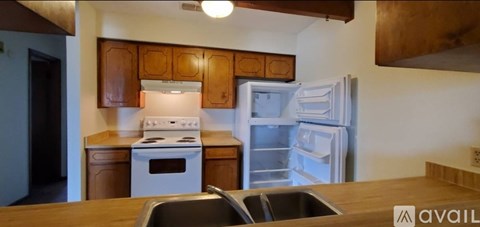 A kitchen with a white stove and a white refrigerator.