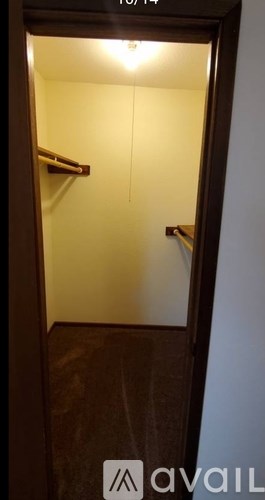 A small dark room with a door and a light on.