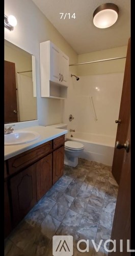 A bathroom with a toilet, sink, and mirror.