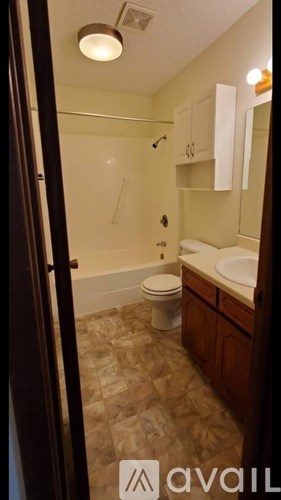 A bathroom with a toilet, sink, and mirror.