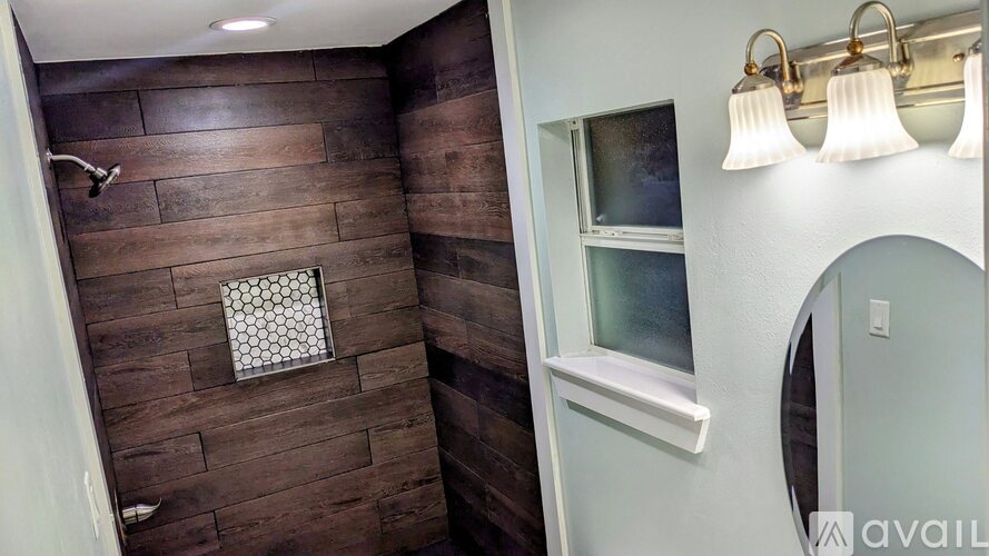 A bathroom with a shower and a window.