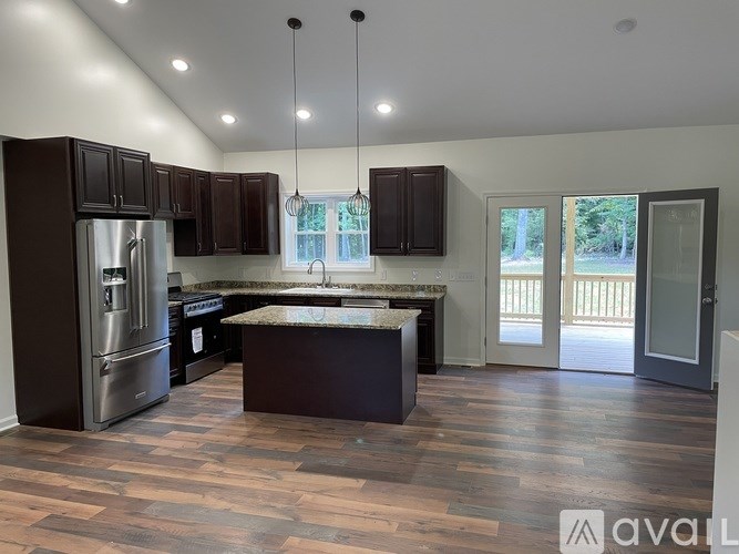 A kitchen with dark brown cabinets and a stainless steel refrigerator.
