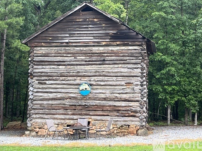 A wooden cabin with a blue sign on it.