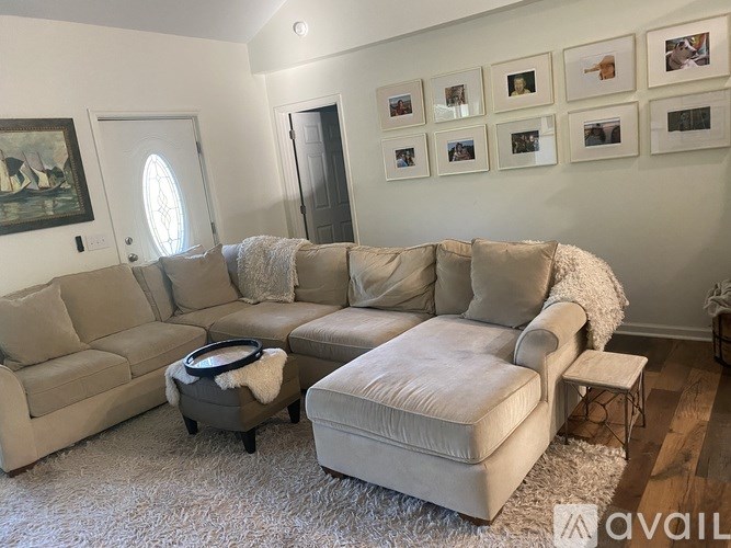 A living room with a large sectional sofa and ottoman.