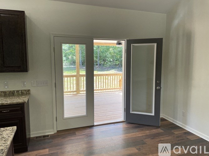 A room with a marble countertop and a door leading to a deck.