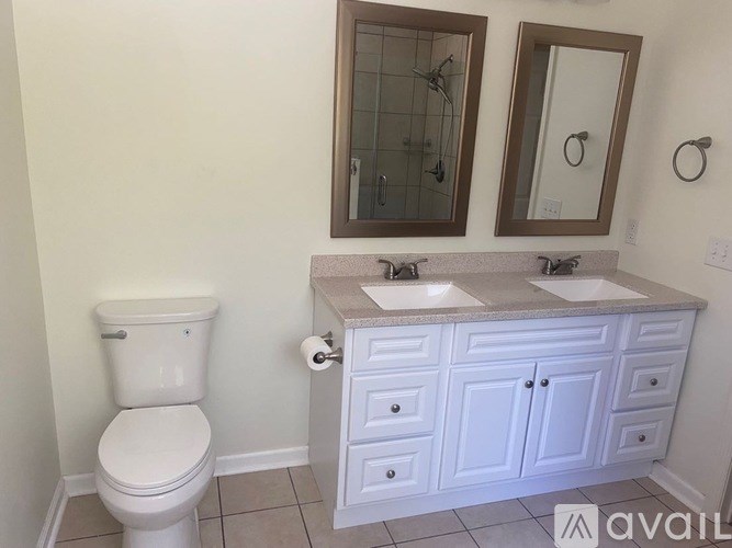 A white toilet sits next to a bathroom sink with a brown countertop.