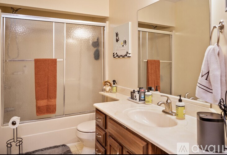 A bathroom with a toilet, sink, and a mirror.