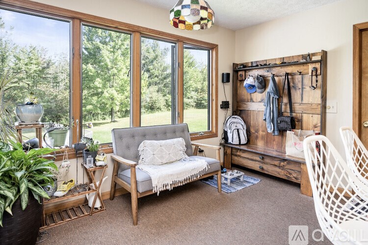 A sunny room with a grey couch and a wooden bench.