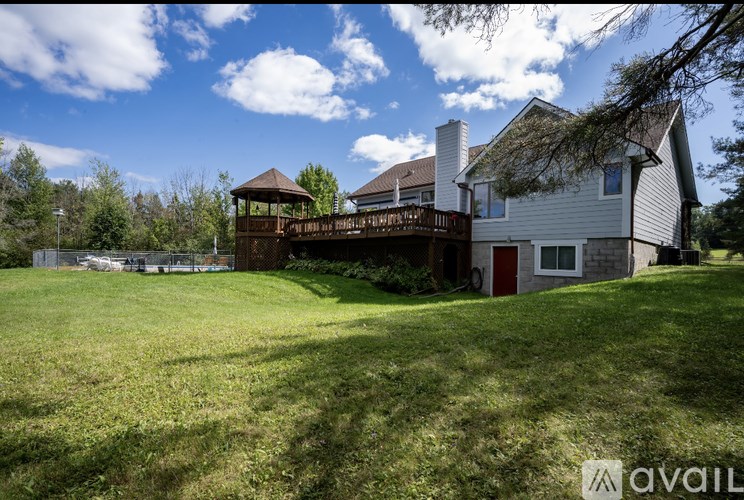 A house with a deck and a gazebo in the backyard.