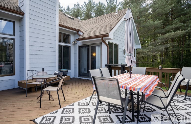 A patio with a striped tablecloth and chairs.