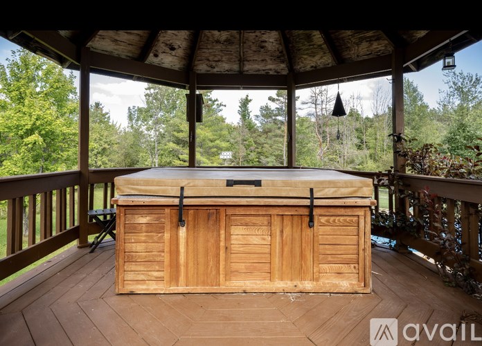 A hot tub on a wooden deck with a view of the forest.