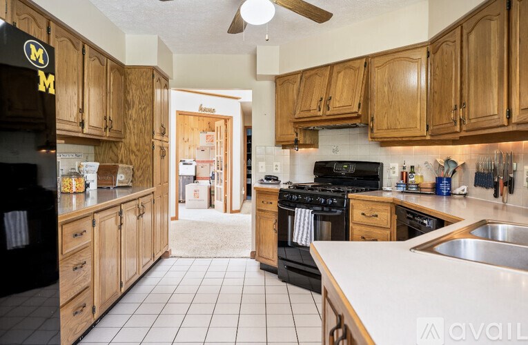 A kitchen with wooden cabinets and a black fridge.