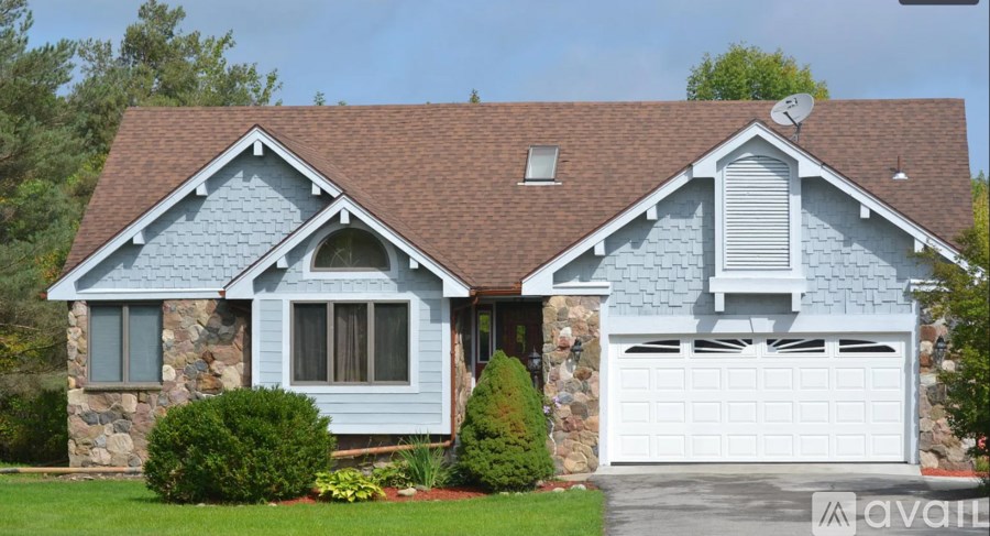A house with a garage and a driveway is for sale.