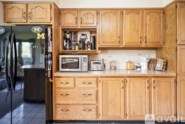 A kitchen with wooden cabinets and a refrigerator with a magnet on it.