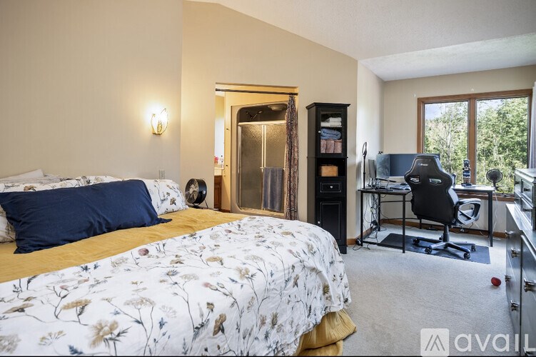 A bedroom with a floral bedspread and a blue pillow.