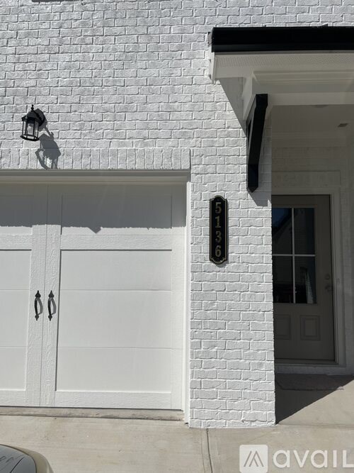 A white house with a black number 63 on the wall.