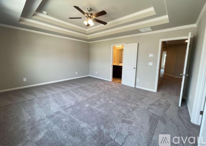 A room with a ceiling fan and carpeted floor.