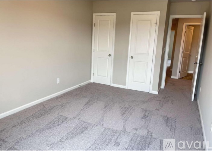 A room with two doors and a carpeted floor.