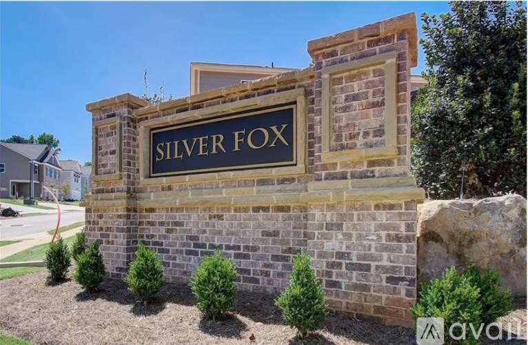 A sign that says "SILVER FOX" is mounted on a brick wall.
