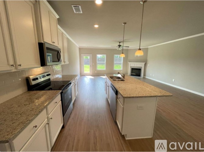 A kitchen with white cabinets and a granite countertop.