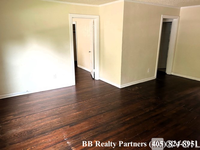 A room with wooden floors and two doors.