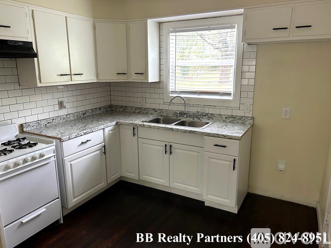 A kitchen with white appliances and cabinets.