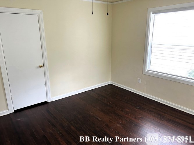 A room with a white door and a window with blinds.