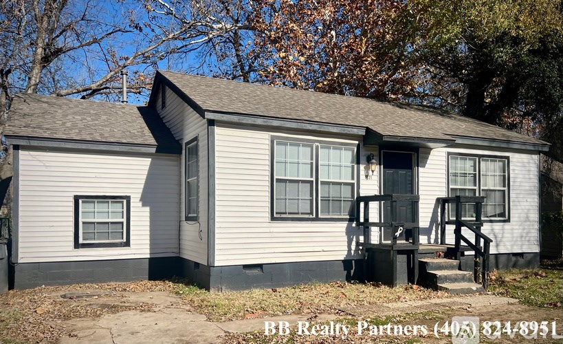 A house with a porch and a BB Realty Partners sign in front.