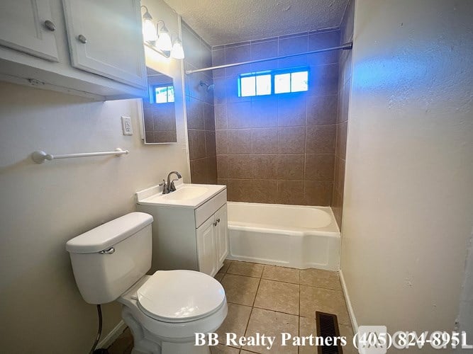 A small bathroom with a toilet, sink, and bathtub.