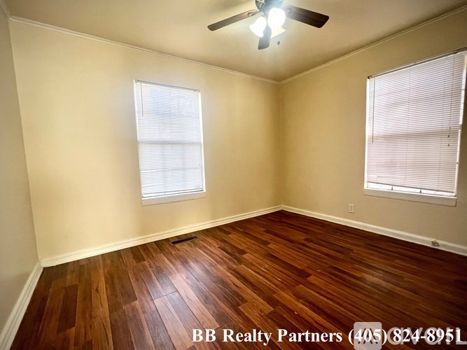 A room with wooden floors and a ceiling fan.