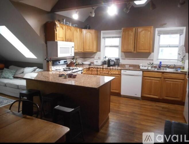 A kitchen with wooden cabinets and a large island.
