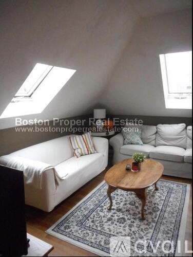 A living room with a white couch and a wooden coffee table.