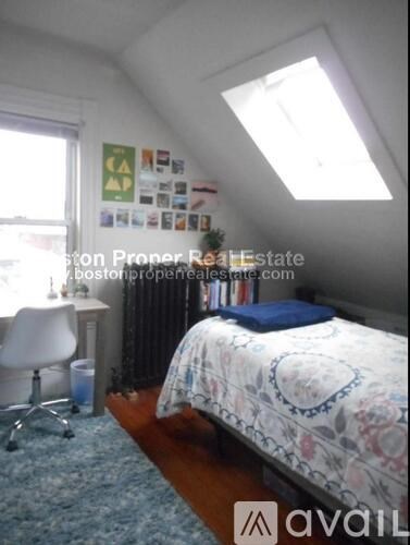 A bedroom with a bed, desk, and chair.