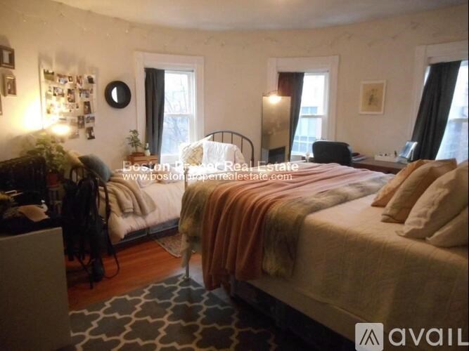 A bedroom with two beds and a desk.