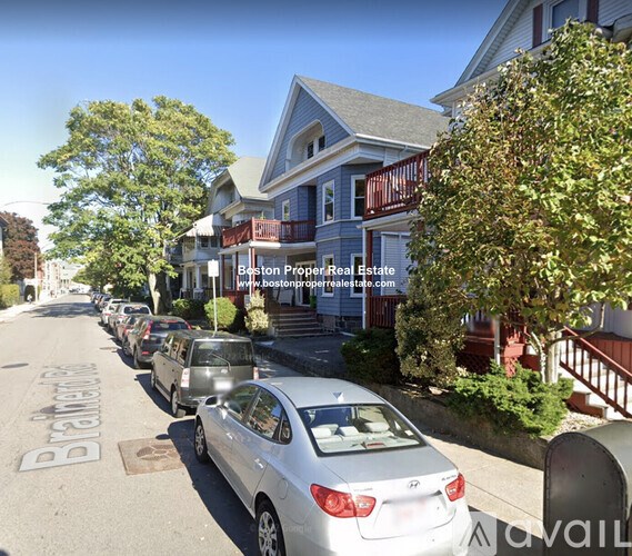 A street view with cars parked on the side and a house with a sign that says "Bastion Property Real Estate".