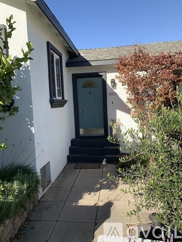 A white house with a blue door and a small window.