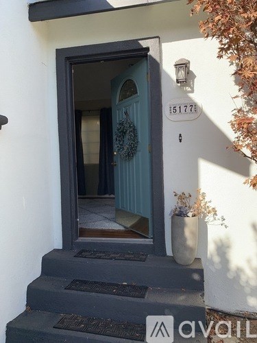 A white house with a blue door and a wreath on it.