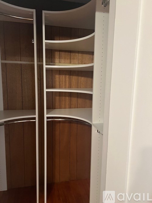 A white shelving unit with wooden shelves.