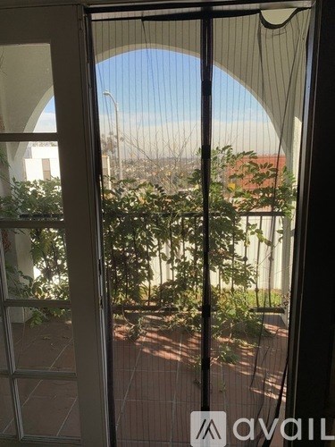 A window with a view of a cityscape and trees.