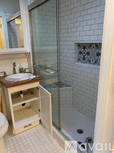 A bathroom with a toilet, sink, and shower.