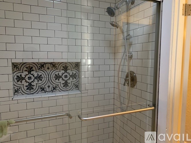 A bathroom with a shower and tiled walls.